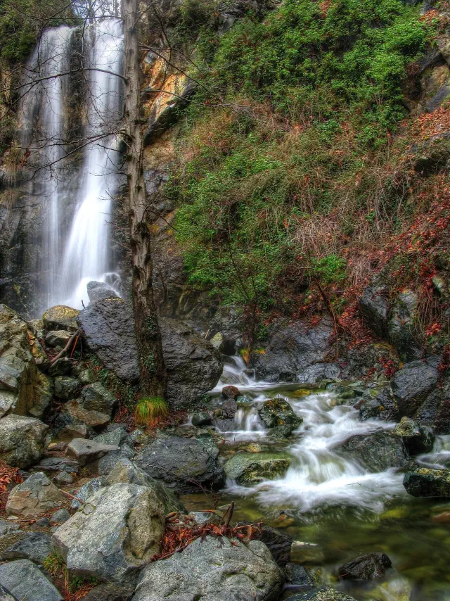 De Caledonia-waterval bij Platres valt over een rotswand in de keienbedding van de Kryos De Caledonia-waterval bij Platres valt over een rotswand in de keienbedding van de Kryos